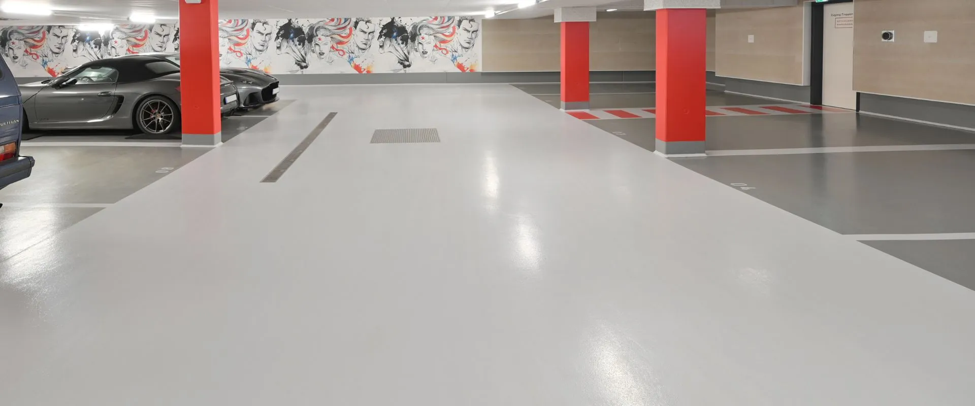 Pohled na umělecky zpracované podzemní parkoviště s vyobrazeními komiksových superhrdinů na stěnách